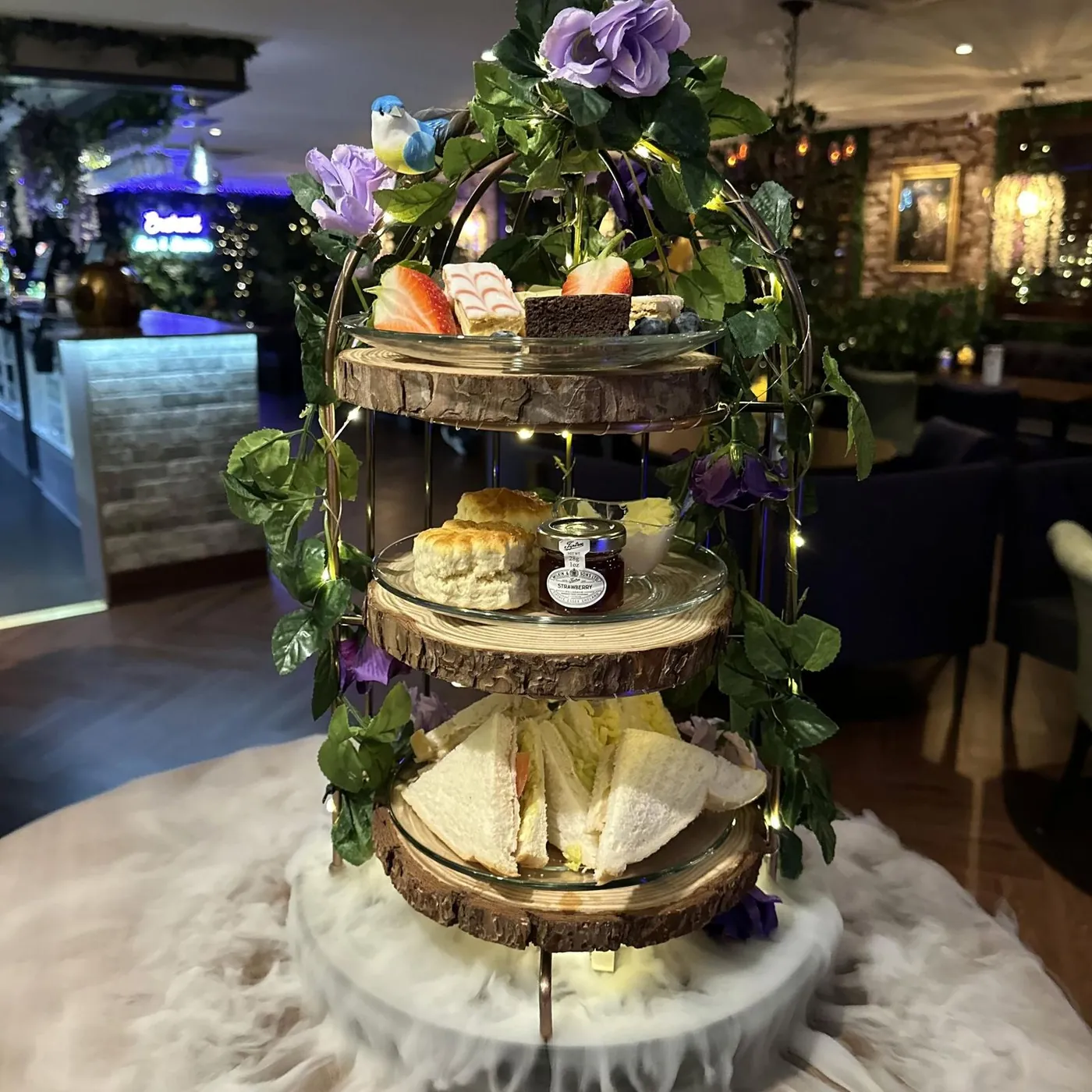 Enchanted afternoon tea stand filled with cakes and sandwiches
