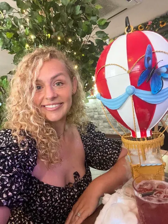 A guest beside the Enchant hot air balloon